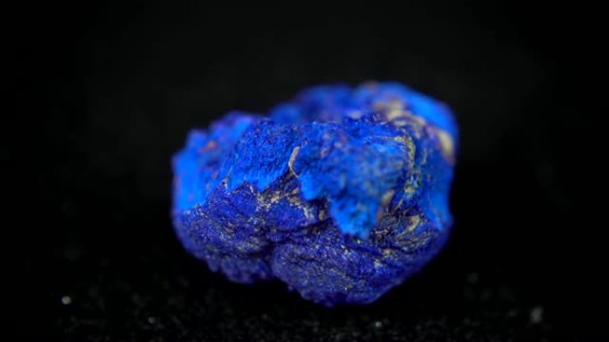 在黑色背景前无缝旋转蓝色矿物 (Azurite)