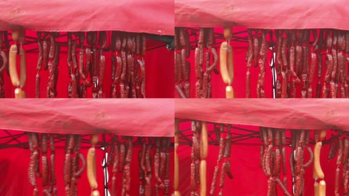 街头市场上的架子上悬挂着许多红色香肠