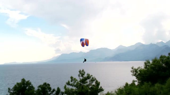 在海上滑翔伞，可以看到山脉和绿色