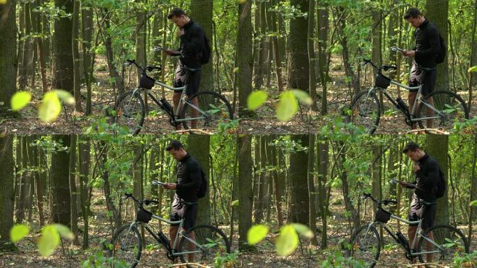骑自行车的人站在森林里，看地图