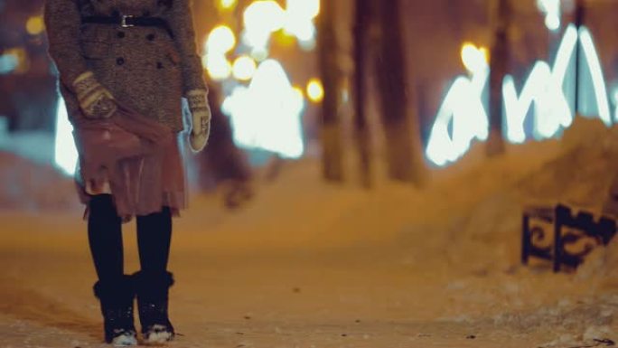 女孩在冬天走在街上。路上有雪。底视图。