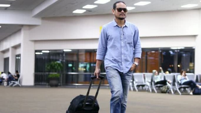 4k亚洲男子旅行者带着手提箱在机场散步和运输