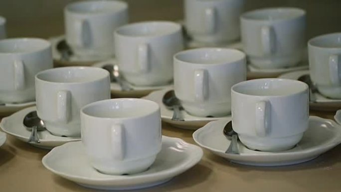 桌子上有许多白色茶杯