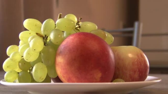 白色背景上的水果翻盘，葡萄，桃子，苹果