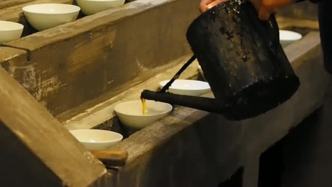 惠州墨棒系列怎么做，第一步，将桐油 (中国木油) 倒入碗中收集黑烟，墨棒的原料，中国文化的传统技术。