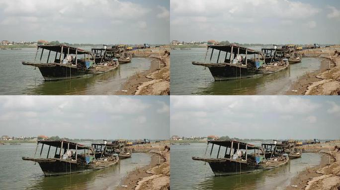 两艘疏浚船绑在河岸上