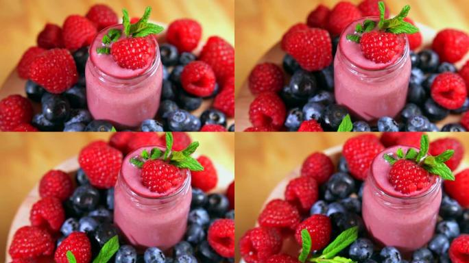 浆果背景上有草莓和蓝莓和薄荷的清淡甜点的玻璃。4K
