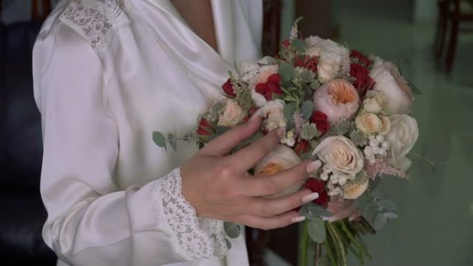 新娘看着婚礼花束并纠正它。