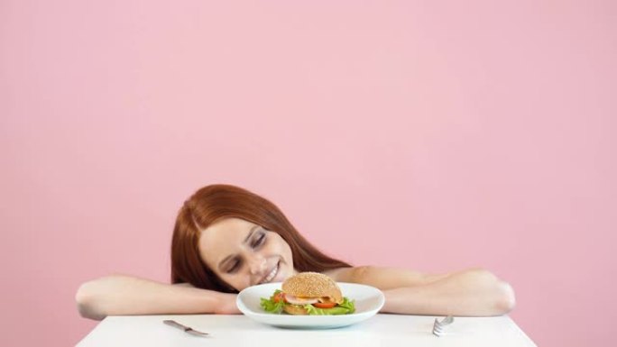 快乐厌食症女孩挣扎着吃汉堡的诱惑