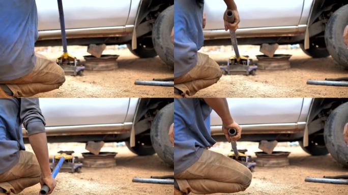 机械师的手使用汽车千斤顶抬起卡车以修理叉骨控制臂并更换汽车的前轮