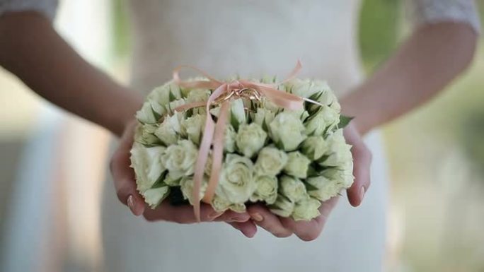 新娘拿着一束鲜花和结婚戒指