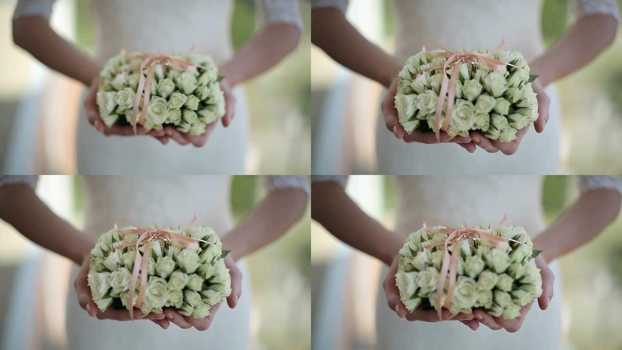 新娘拿着一束鲜花和结婚戒指
