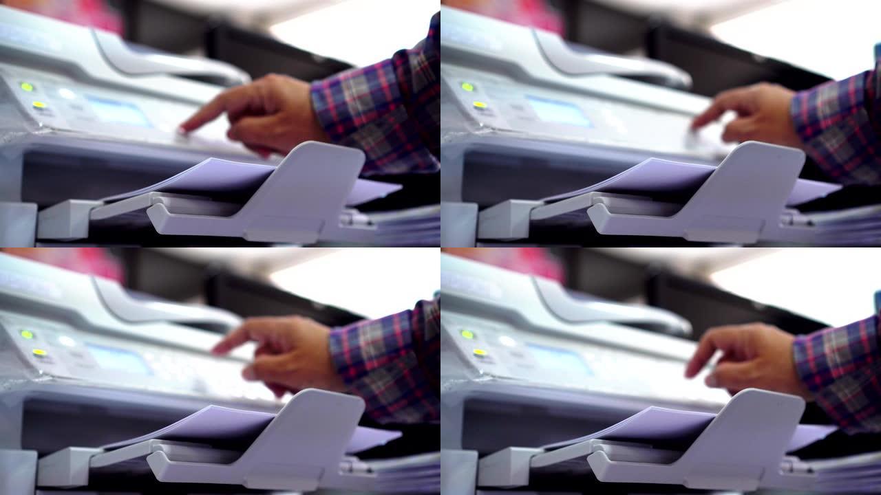 商务办公概念: 手工商人是在激光打印墨盒上印刷纸张的过程，在繁忙的办公室背景下放下或从打印机上取纸