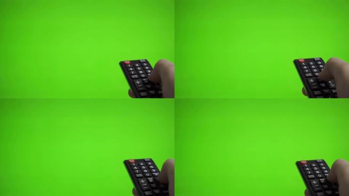 男性手用电视遥控按下绿色屏幕上的频道。你广告的地方。