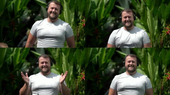 大胡子滑稽的男人穿上衣服，打开音乐，听充满活力的音乐，跳舞。特写