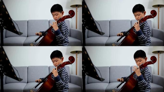 亚洲男孩在室内学习大提琴