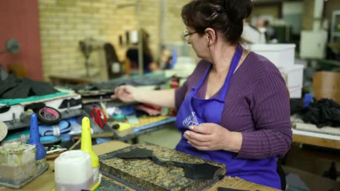 妇女在制鞋中使用锤子