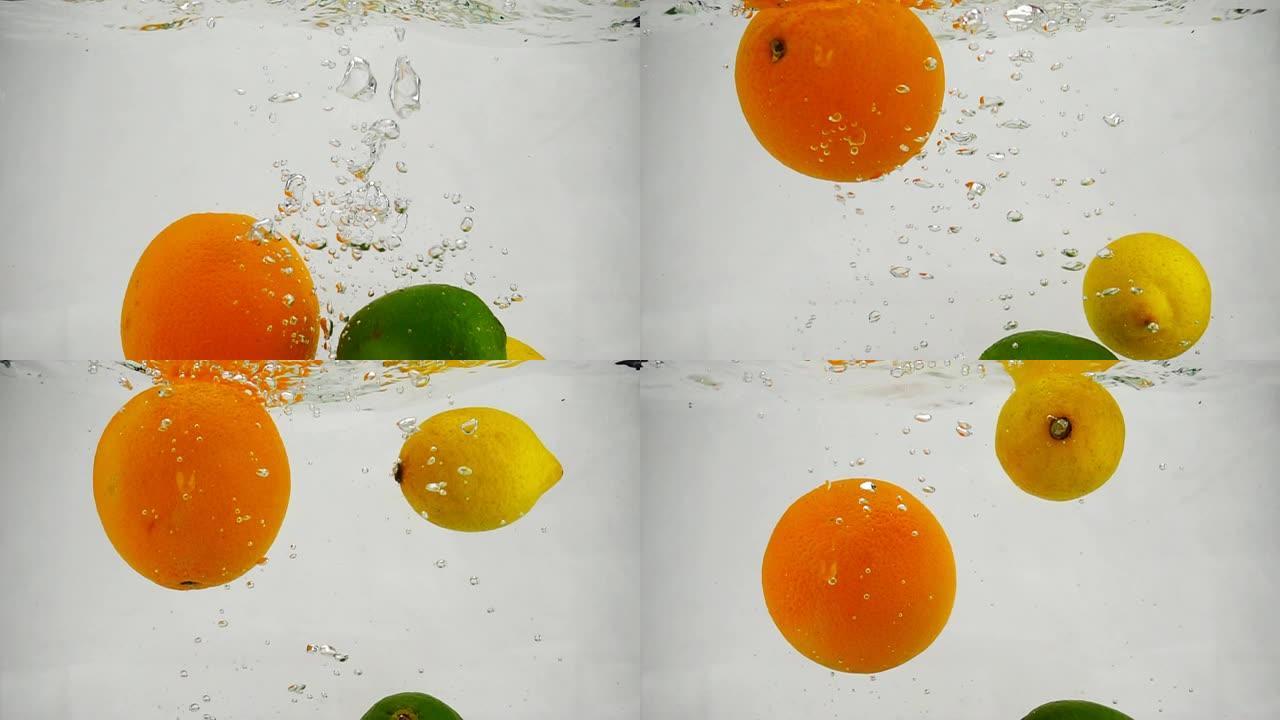 柠檬，石灰和橙子落入水中的慢动作视频带有气泡。孤立白色背景上的柑橘类水果。