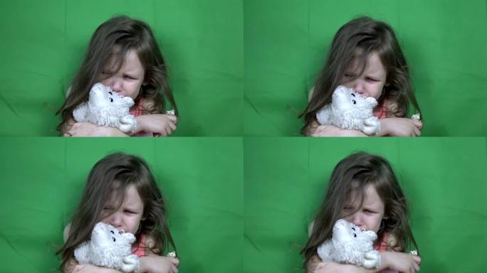 小女孩哭着拿着一个柔软的玩具。