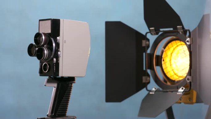 蓝色背景上的复古发条电动8毫米电影相机