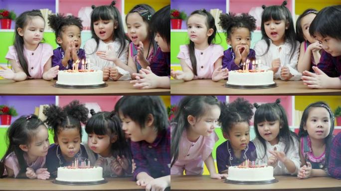 团体多样性儿童吹生日蛋糕。