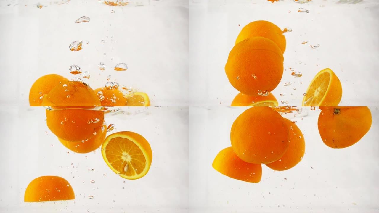 碎裂的橙子迅速沉入水中，带有气泡，慢动作特写
