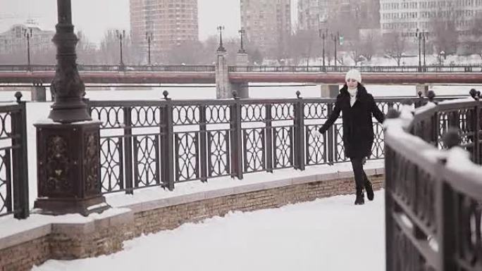 美丽快乐的女孩在冬天在桥上奔跑