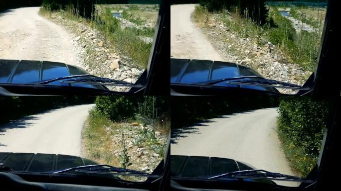 POV驾驶吉普车在绿色植物之间的崎岖道路上行驶