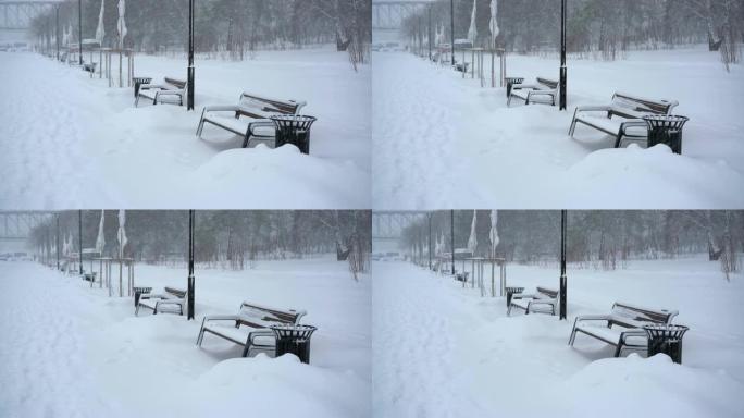 降雪下的冬季街道上的长凳和路灯