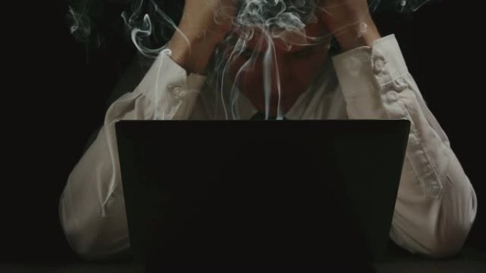 商人在吸烟的笔记本电脑前抓着头-慢动作