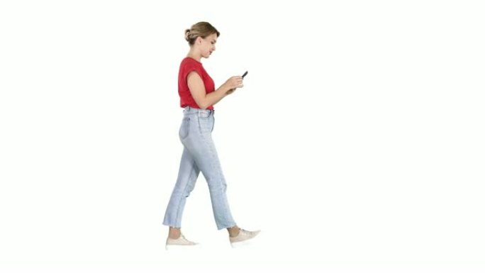 美丽的年轻女子在白色背景上的手机上走路和阅读短信