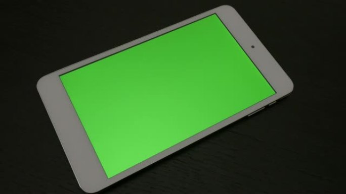 木质表面带绿屏显示的银色桌子缓慢平移4K 3840X2160 UHD镜头-在带有绿屏显示的PC平板电