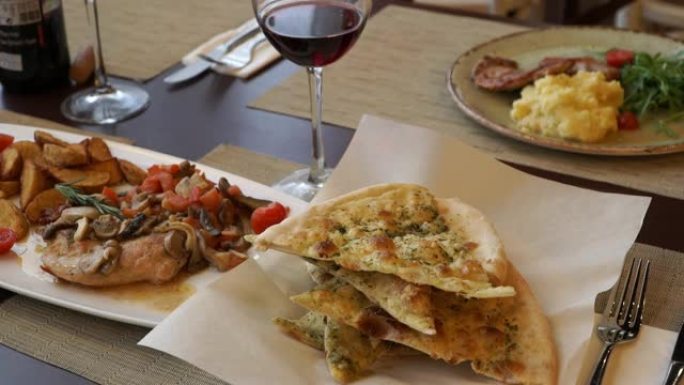 在一家餐厅的肉菜和一杯红酒的背景下，意大利意式薄饼的特写镜头