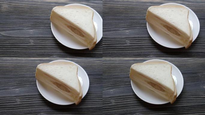 三明治黄油和bolona切片放在木桌上，早餐面包食物美味可口，运动。