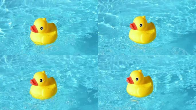 在夏日的灯光下，黄色的橡皮鸭可以在水池的波光粼粼的清澈水中放松地漂流。