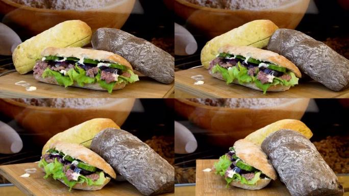 旋转镜头围绕堆满沙拉、奶酪和火腿配料的恰巴塔面包卷。