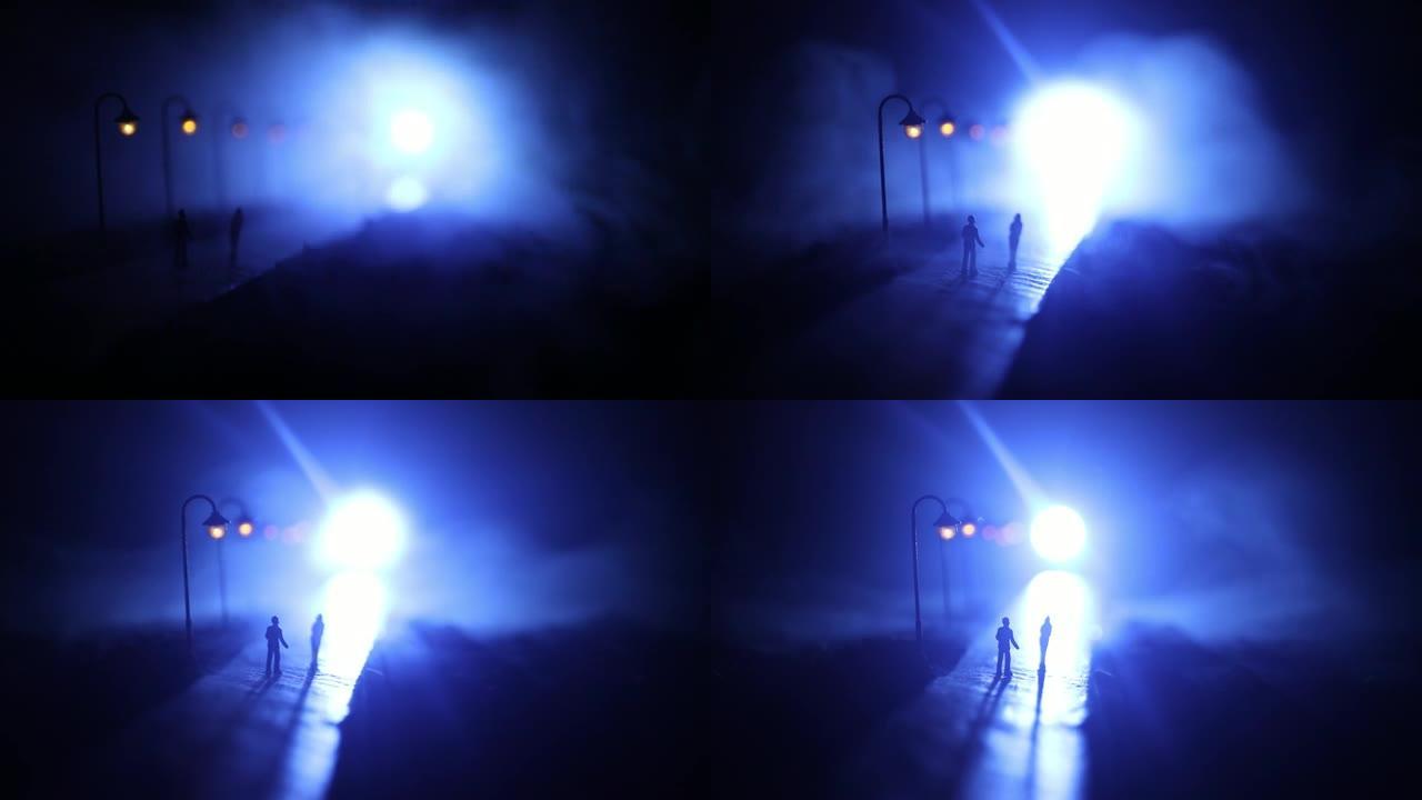 艺术品装饰。夜晚在路灯下行走的夫妇的剪影。薄雾中的宁静气氛。有雾的空气。爱情概念。选择性聚焦