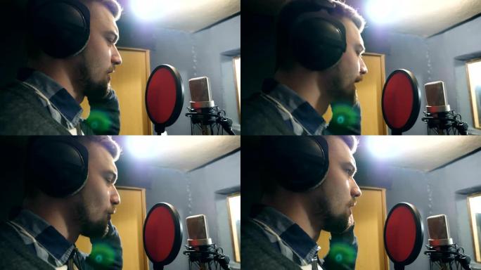 耳机男歌手的简介在sound studio的麦克风中演唱歌曲。年轻人录制新的旋律或歌曲。创意音乐家的