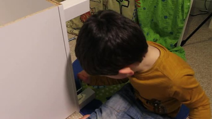 小男孩建造一个自组装的衣柜