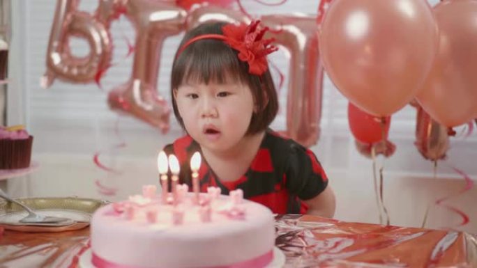 蹒跚学步的女孩在家庆祝她的三岁生日