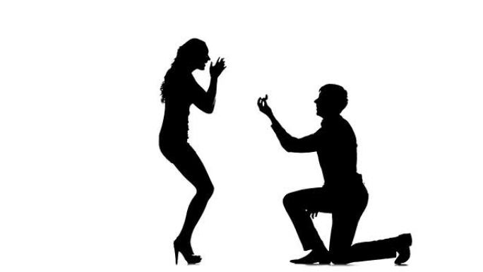 男人单膝亲吻女人的手的剪影。慢动作