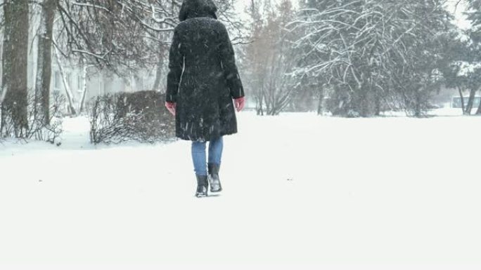 冬日在暴风雪中走到外面的妇女