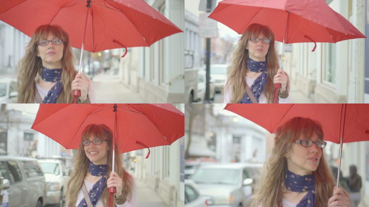 手持红伞的美女在雨中行走