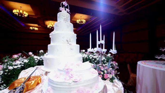 婚礼招待会上用鲜花装饰的漂亮婚礼蛋糕。