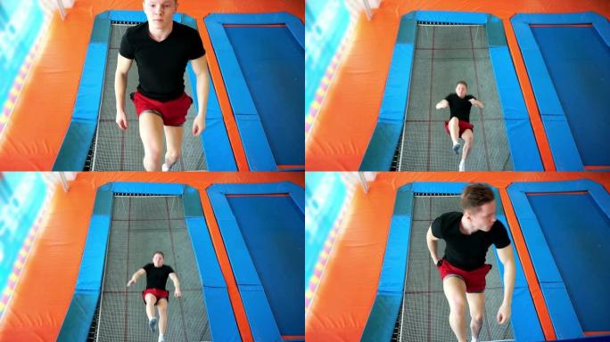 一个年轻人跳上运动蹦床。