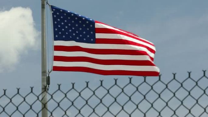 美国国旗在安全围栏后随风飘扬