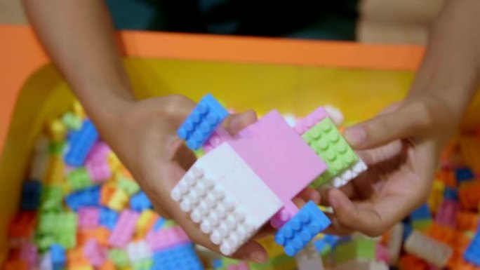 特写女人的手在玩彩色建筑塑料砖块。