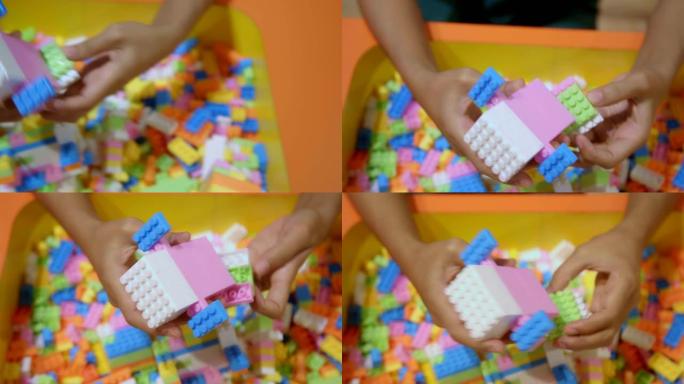 特写女人的手在玩彩色建筑塑料砖块。