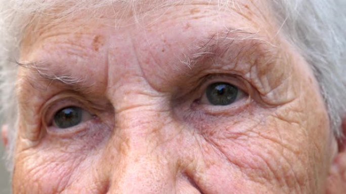 闭上祖母的灰色眼睛，周围有皱纹。高级女士的肖像带着悲伤的景象望着远方。老年妇女的悲伤面部表情。