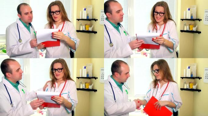 两个微笑的医生男人和女人讨论看病人文件夹的情况